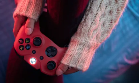 Uma pessoa segurando um joystick de Xbox