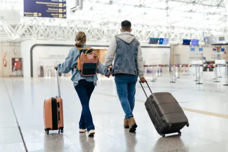 Turismo e cultura geek: 5 destinos para quem ama quadrinhos Couple at the airport walking to board